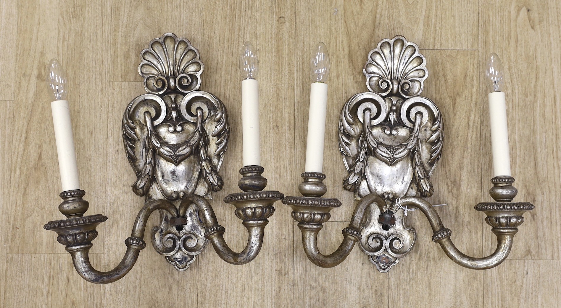 A pair of baroque style silvered wood two branch wall sconces